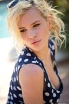 Catie Parker pulls down her polka dot dress under the glowing sun