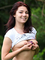 Girl with pierced nipples and belly spreading legs outdoor