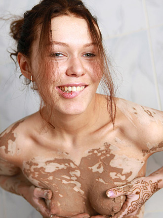 Hot naked teen getting very dirty with the mud in her bathroom