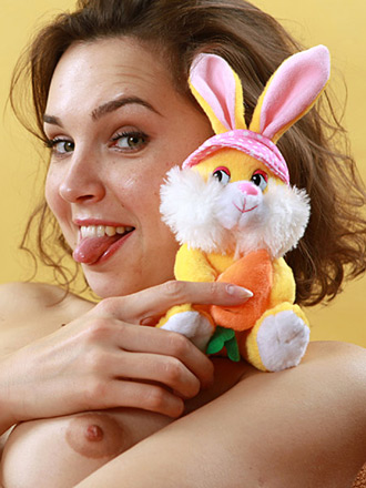 Adorable babe with small lumps is playing with her lovely rabbit indoors