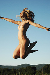 Naked teen girl jumping naked on the meadow