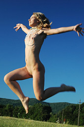Naked teen girl jumping naked on the meadow