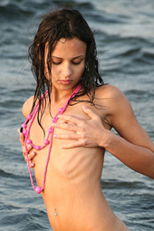 Brunette teen getting wet in the sea