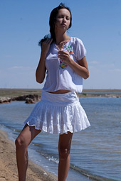 Sexy brunette teen posing bottomless on the beach