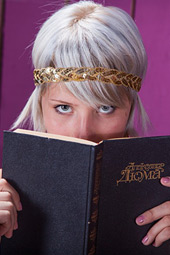 Brave goddess blonde is reading her favorite book on the chair indoors