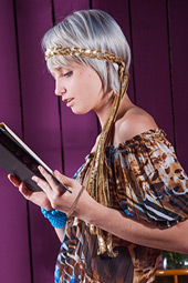 Brave goddess blonde is reading her favorite book on the chair indoors