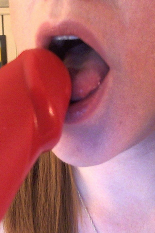 Lucy Ohara has some fun with her red diablo dildo while on her bed