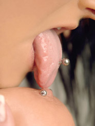 Piercing - Brunette Lilly loves to pose and is pushing her big natural tits. See her feminine naked body and tounge licking her nipple piercing.